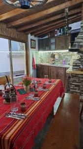 une table dans une cuisine avec un tissu de table rouge dans l'établissement Къща под наем-нощувки, à Targovichté