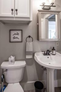 a bathroom with a toilet and a sink and a mirror at The T-town Yorkshire Flat in Tulsa