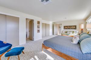 パーム・スプリングスにある2 Mi to Downtown Luxe Palm Springs Home!の青いベッドとソファ付きの広いベッドルーム1室が備わります。 +32枚の写真