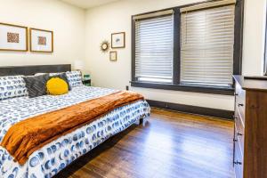 a bedroom with a bed and two windows at Pleasantly Plush - Quality and Comfort Downtown in Tulsa