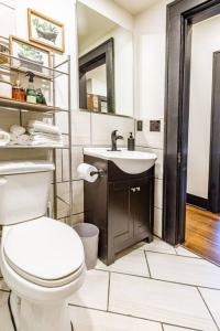 een badkamer met een wit toilet en een wastafel bij Pleasantly Plush - Quality and Comfort Downtown in Tulsa