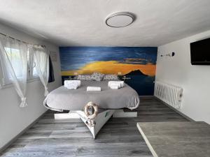 a bedroom with a bed and a painting on the wall at 43° Parallelo in Campiglia Marittima