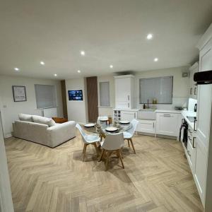 a kitchen and a living room with a table and chairs at Ground Floor Stratford Flat in Stratford-upon-Avon