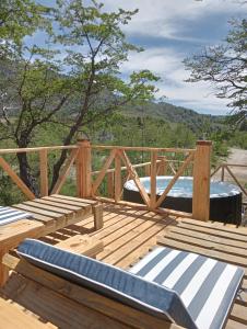 eine Holzterrasse mit einem Bett darüber in der Unterkunft Tierras Mágicas in Villa Pehuenia