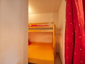 een kleine kamer met een stapelbed met een rood gordijn bij Appartement Morillon 1100, 2 pièces, 6 personnes - FR-1-642-11 in Morillon