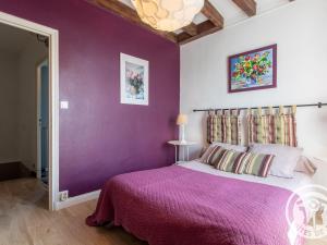 a bedroom with purple walls and a bed with a pink bedspread at Gîte Savennières, 2 pièces, 2 personnes - FR-1-622-18 in Savennières