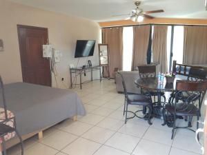 - une chambre avec un lit, une table et une télévision dans l'établissement Estudio Frente Al Mar Posada, à San Carlos