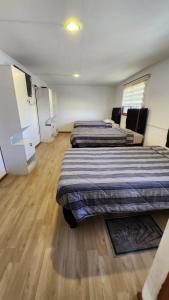 Duas camas num quarto com pisos em madeira em Residencial F y V Spa em Rancagua