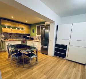 eine Küche mit einem Tisch und einem Kühlschrank in der Unterkunft Villa du Parc de Vaugrenier in Villeneuve-Loubet