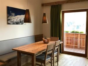 a dining room table with chairs and a window at Ferienwohnung Neubau in Alpbach