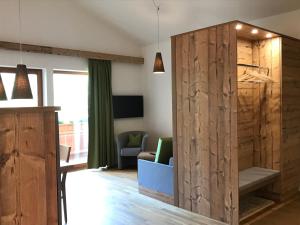 a living room with a wooden partition and a couch at Ferienwohnung Neubau in Alpbach