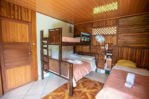 Zimmer mit 2 Etagenbetten und einer Tür in der Unterkunft Tío Felix Eco Lodge in Fortuna