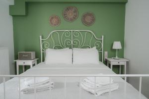 Dormitorio verde con cama con almohadas blancas en K-houses P, en Lefkada