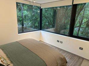 ein Schlafzimmer mit zwei großen Fenstern und einem Bett in der Unterkunft Apartamento Nuevo Pucón in Pucón + 11 Fotos