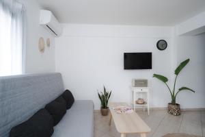 Sala de estar blanca con sofá y mesa en K-houses P, en Lefkada