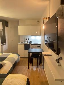 a small room with a kitchen and a table in it at T2D Apartment - Suite UR proche Disneyland Paris in Bussy-Saint-Georges