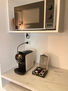 a microwave and a toaster sitting on a shelf at T2D Apartment - Suite UR proche Disneyland Paris in Bussy-Saint-Georges