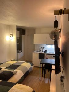 a bedroom with a bed and a table and a kitchen at T2D Apartment - Suite UR proche Disneyland Paris in Bussy-Saint-Georges