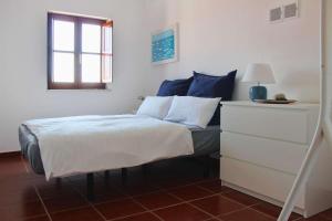 a bedroom with a bed and a dresser at Penthouse Alentejana in Vila Nova de Milfontes