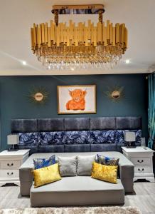 ein Wohnzimmer mit einem Sofa und einem Kronleuchter in der Unterkunft FINN VILLAGE – Loch Lomond Luxury Lodges with All Year-Round Hot Tubs and Gazebos in Glasgow
