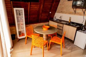 uma cozinha com uma mesa, cadeiras e um fogão em CHALE DAS ESTRELAS em Piçarras