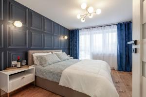 a bedroom with a bed and a blue wall at BOMBONIERKA Apartamenty in Krynica Zdrój