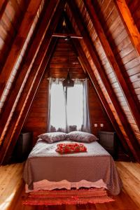 um quarto com uma cama num sótão de madeira em CHALE DAS ESTRELAS em Piçarras
