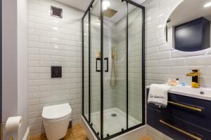 a bathroom with a shower and a toilet and a sink at BOMBONIERKA Apartamenty in Krynica Zdrój +33 photos