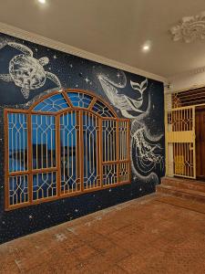 a room with a wall with a door and a mural at Unpack Hostel in Pondicherry