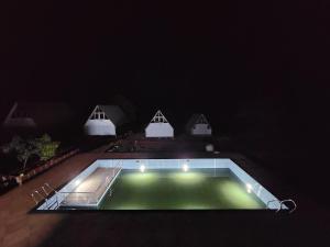 uma vista nocturna para uma piscina no escuro em Nirved Retreat - A Backwater Forest Stay. 