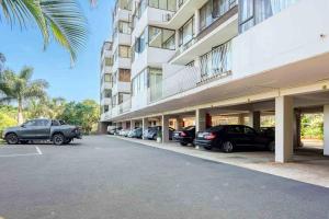 a parking lot with cars parked in front of a building at Lovely 2-bedroom apartment, with an amazing view in Durban