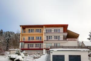 a large building with snow in front of it at BOMBONIERKA Apartamenty in Krynica Zdrój