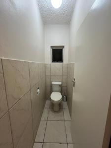 a bathroom with a toilet and a television in it at Robridon in Summerstrand