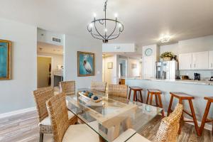 a dining room and kitchen with a glass table and chairs at Shores of Panama III in Panama City Beach