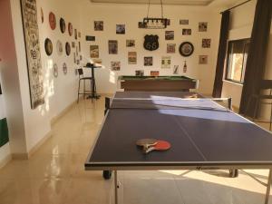 uma mesa de pingue-pongue numa sala com uma raquete de pingue-pongue em 3 Bedroom mountain view apartment overlooking Al Fuhais em Amã
