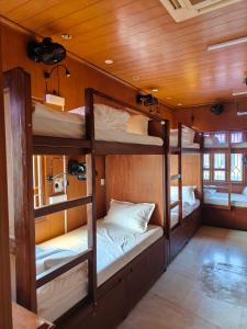 a room with three bunk beds in a boat at Unpack Hostel in Puducherry