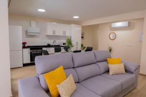 salon z szarą kanapą z żółtymi poduszkami w obiekcie Sol y Mar Boutique Apartments w Alicante