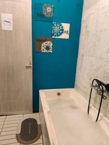 蓬蒂切里Unpack Hostel的带浴缸和蓝色墙壁的浴室