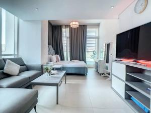 a living room with a couch and a bed and a tv at Key View - Hilliana Tower in Dubai