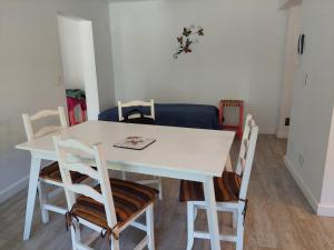 - une table et des chaises blanches dans la chambre dans l'établissement Antón SMAndes, à San Martín de los Andes