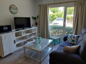 a living room with a couch and a tv and a table at Antón SMAndes in San Martín de los Andes