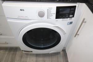 a white washing machine sitting in a kitchen at Ground Floor 1 Bed Flat Dartford- 1 - Fully Equipped - Fibre Wifi - AIRPORT PICK-DROP AVAILABLE in Dartford