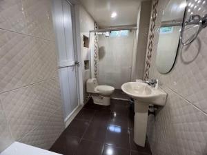 een witte badkamer met een wastafel en een toilet bij Montes De Beraka in Minca