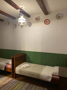 a bedroom with two beds and plates on the wall at Pensiunea Iona in Baia Mare