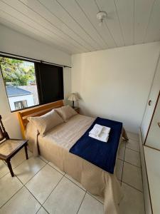 um pequeno quarto com uma cama e uma janela em Light Beach Residence em Florianópolis