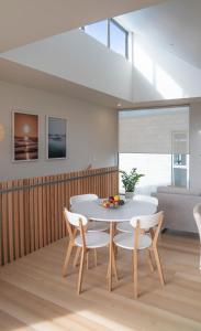 a dining room with a white table and chairs at Coastal Living in Comfort in Raglan