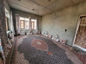 an empty room with a rug in a room with a window at POP Home Sharik Homestay 