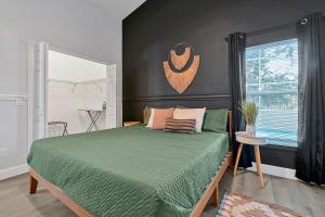 een slaapkamer met een groen bed en een raam bij Your Family Fun Villa w Pool, Game room, all you need, close to Disney & more in Davenport