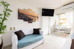 a living room with a white couch and a tv at Holidays2Arroyo de la Miel - Studios with terrace and Pool 800 mts from beach in Arroyo de la Miel