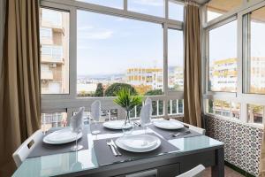 a dining room with a table and large windows at Holidays2Arroyo de la Miel - Studios with terrace and Pool 800 mts from beach in Arroyo de la Miel